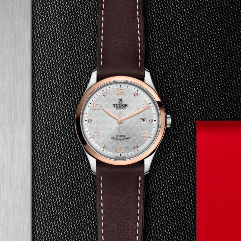 A M91651-0006 with a brown leather strap on a red background.