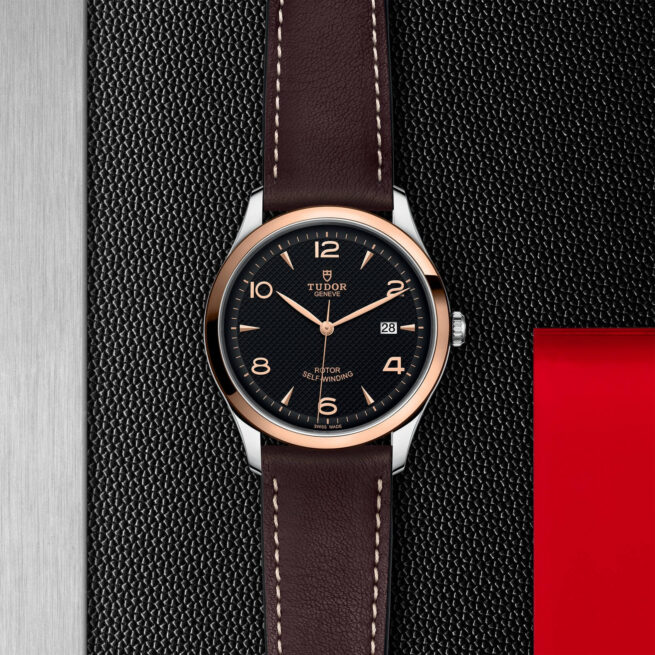 A watch with a M91651-0007 leather strap on a red background.