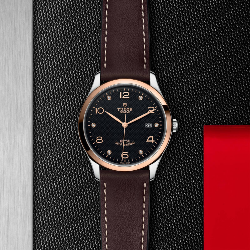 A black and brown M91651-0008 watch on a red background.