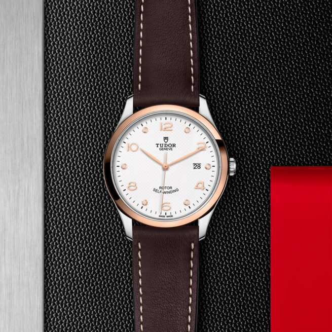 A watch with a brown leather strap on a black background.