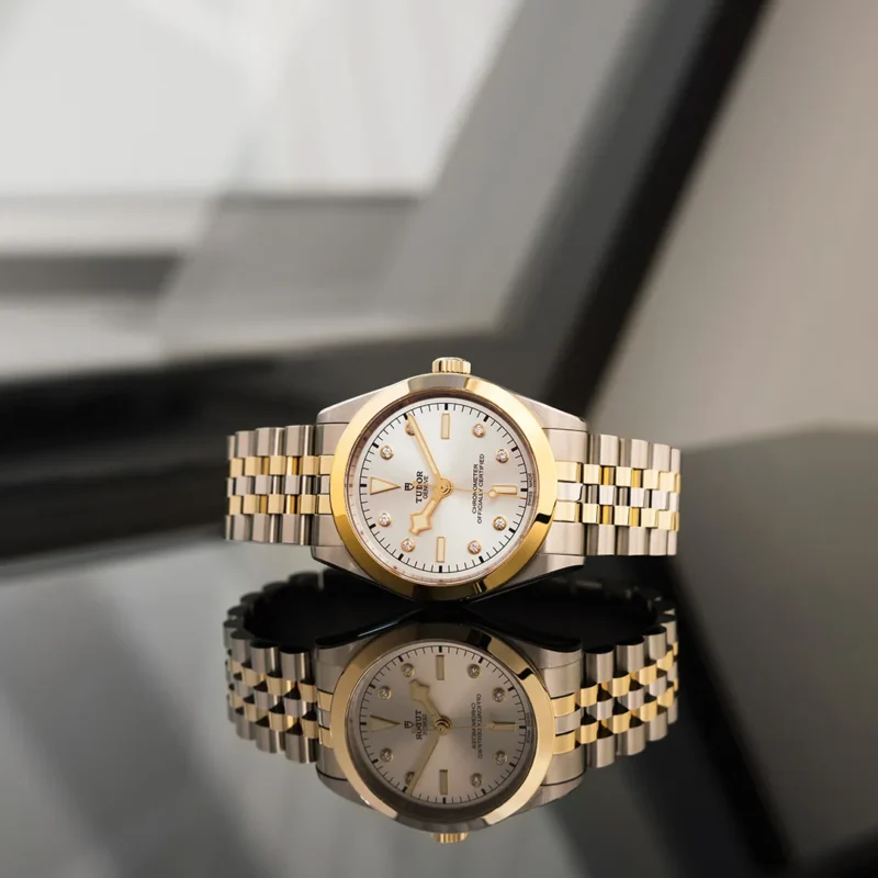 A M79603-0002 ladies watch on a table in front of a window.