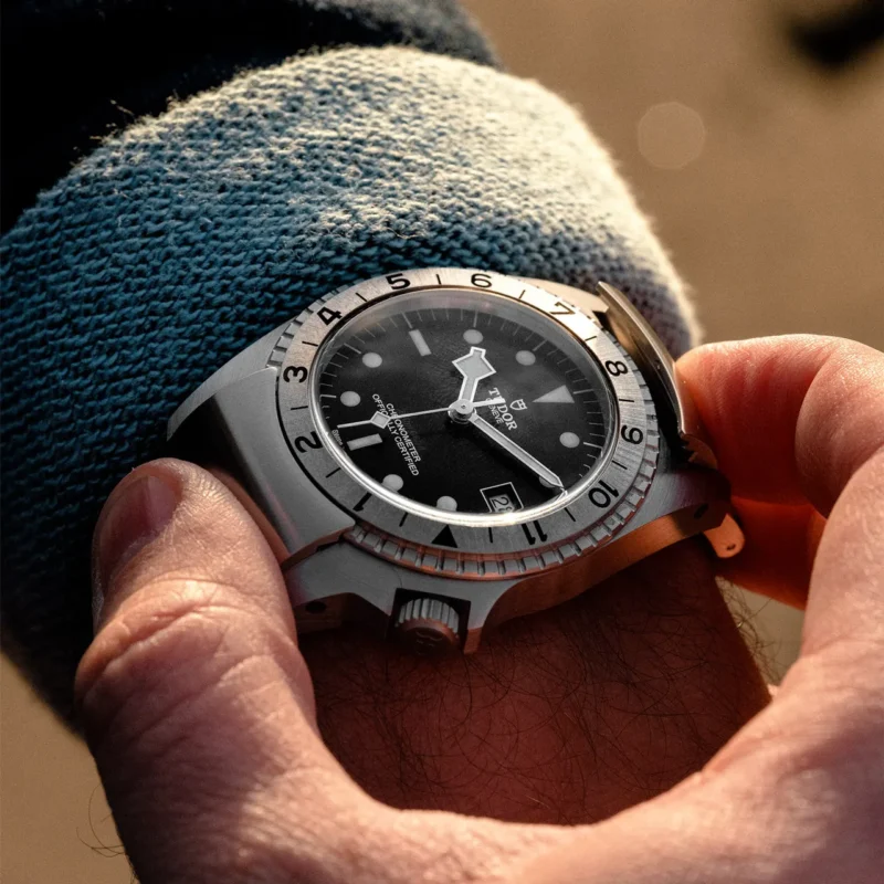 A man is holding a M70150-0001 watch on his wrist.