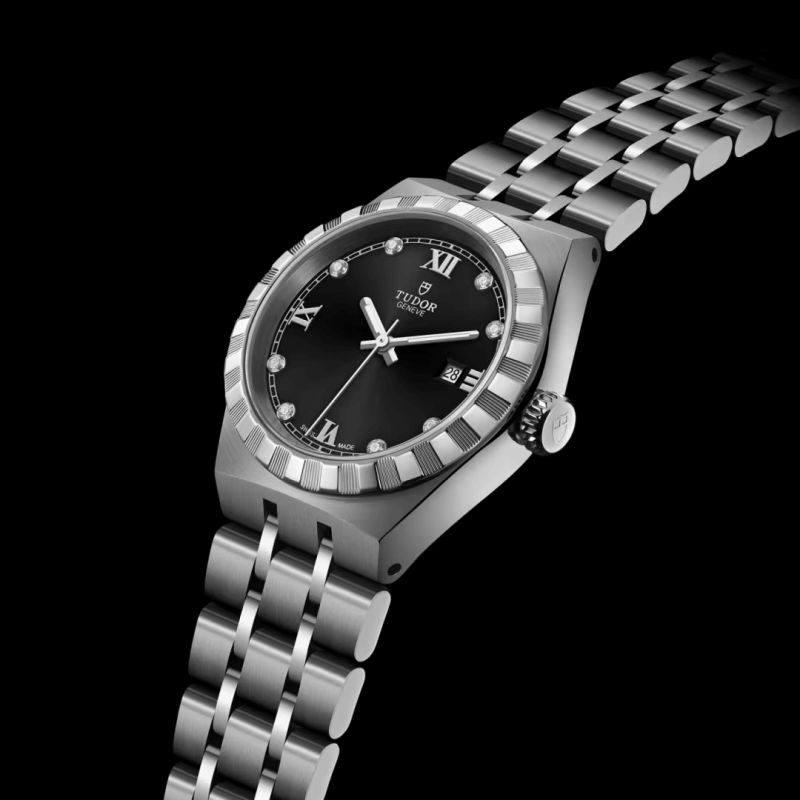 A stainless steel Tudor wristwatch with a black dial, Roman numerals, and a diamond bezel (M28300-0004), displayed on a black background.