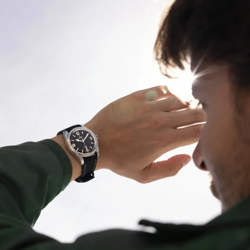 A man wearing an M79950-0002 watch looking at the sun.