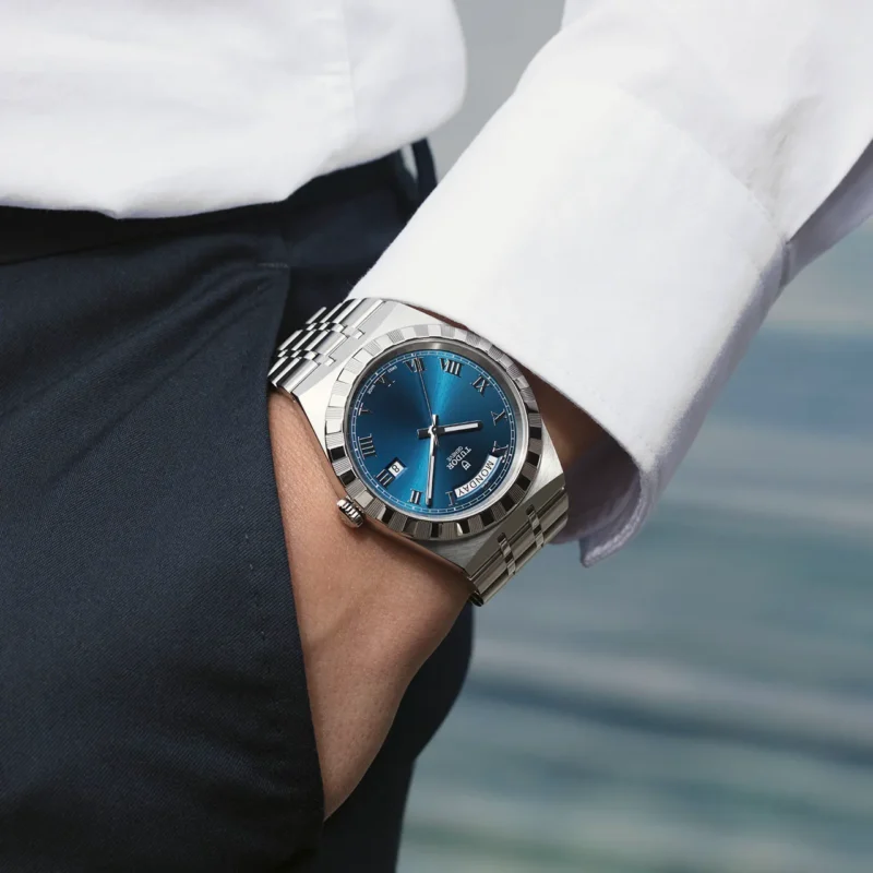 A man's wrist with a blue M28600-0005 watch.