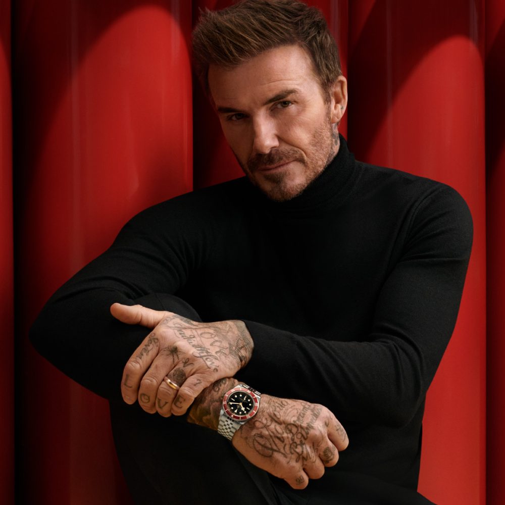 A man wearing a black turtleneck and a tattooed wrist.