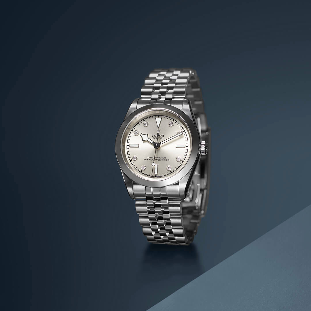 A silver watch on a blue and grey background.