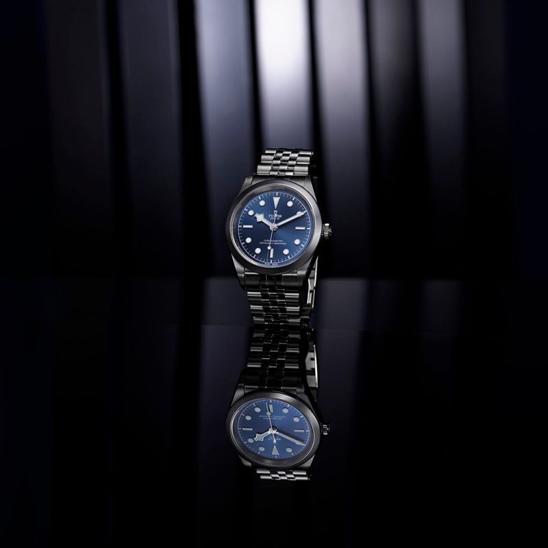 A watch with a blue dial on a black background.