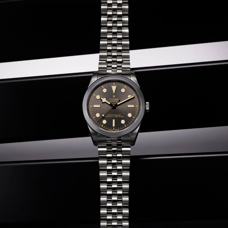 A black and silver watch on a black background.
