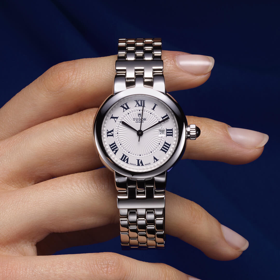 A woman's wrist with a white watch on it.