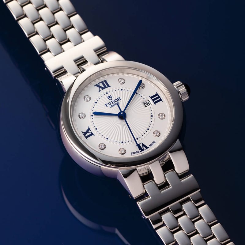 A silver watch with a white face.