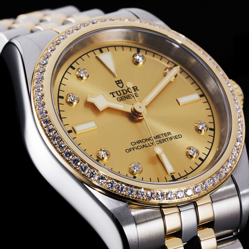 A yellow and gold watch with diamonds.