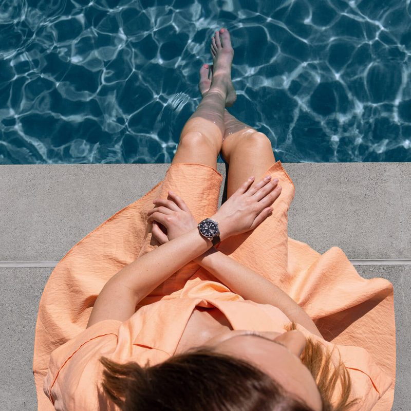 A woman sitting on a pool edge.