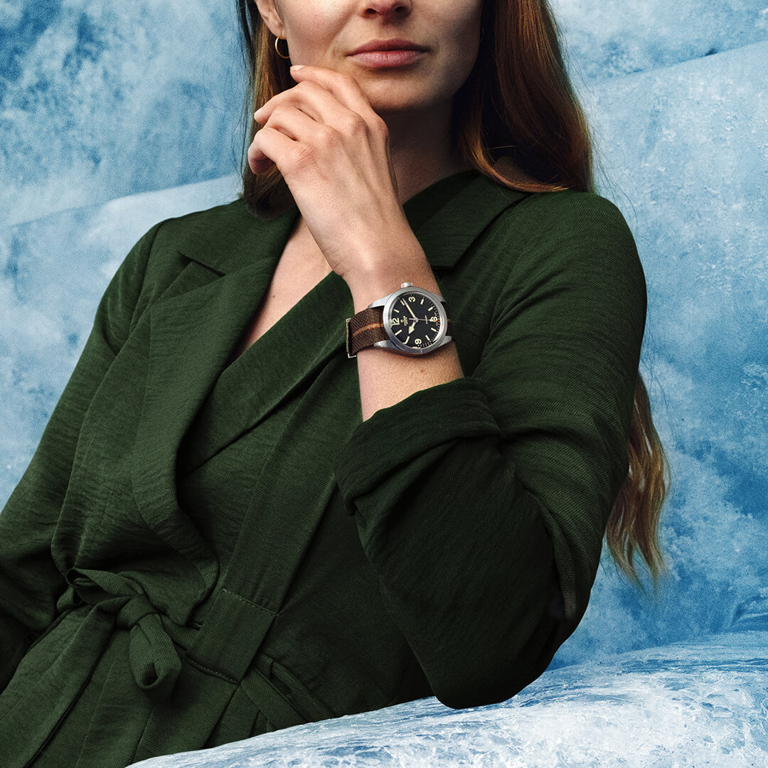 A woman is sitting on a chair with a watch on her wrist.