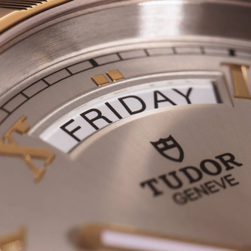 A close up of a tudor watch with the word friday.
