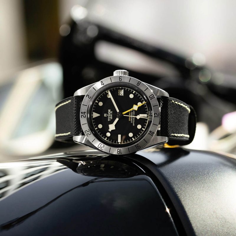 A tudor black bay watch sits on top of a motorcycle.