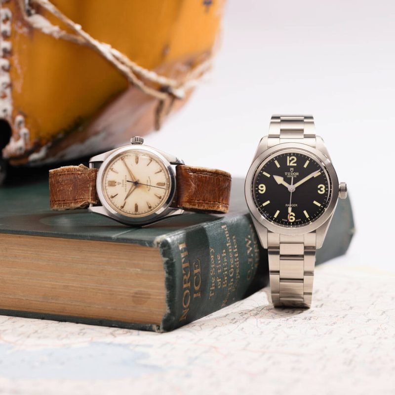 Two watches and a book on a table.