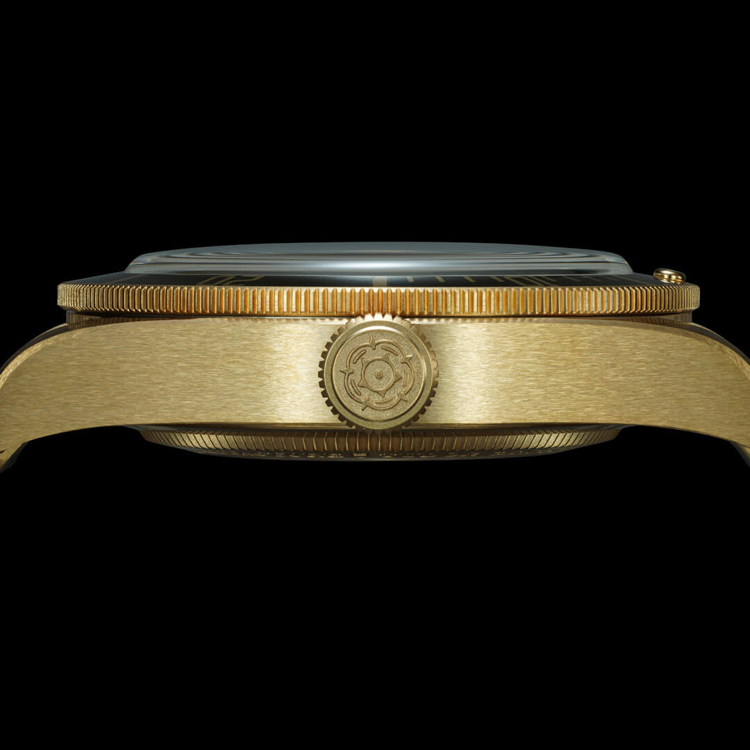 A close-up side view of a gold-colored M79018V-0006 case featuring a decorative crown with an intricate design.