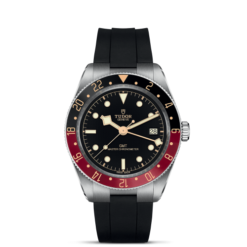 A M7939G1A0NRU-0002 with a black rubber strap, black dial, and a red and black bezel, displaying the date at the 3 o'clock position. The brand name "Tudor" is visible on the dial.