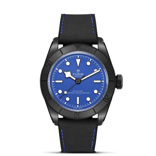 A wristwatch with a blue dial, black bezel, and black strap. The brand name "Tudor" is on the dial.