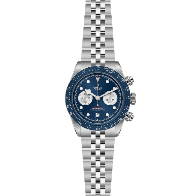 A silver wristwatch with a blue dial, three subdials, a date display at 6 o'clock, and a stainless steel bracelet. The watch has a tachymeter bezel and pushers on the side.