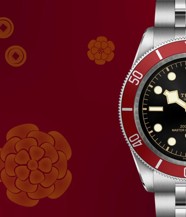 A striking TUDOR dive watch with a red bezel and black dial stands elegantly against a vibrant red floral and coin-patterned backdrop.