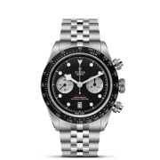 The M79360N-0013 is a silver wristwatch featuring a black dial, three subdials, a date display at 6 o'clock, and a tachymetric scale on the bezel.