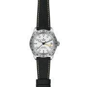 The M79470-0006 is a silver Tudor wristwatch featuring a white dial, black hour markers, a date window at 3 o'clock, a bezel with a 24-hour scale, and a black fabric strap.