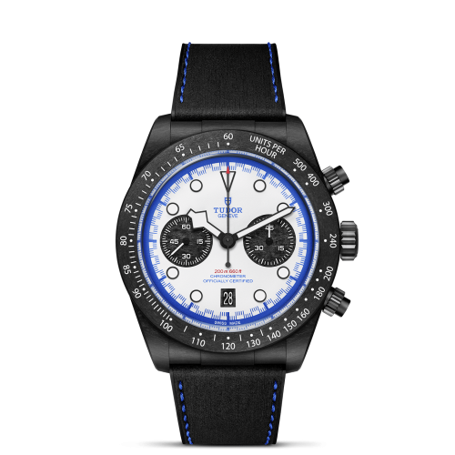 The Tudor M79360B-0002 is a black chronograph watch featuring a white face, black sub-dials, blue accents, a tachymeter bezel, and a black strap with blue stitching.