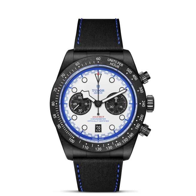 The Tudor M79360B-0002 is a black chronograph watch featuring a white face, black sub-dials, blue accents, a tachymeter bezel, and a black strap with blue stitching.