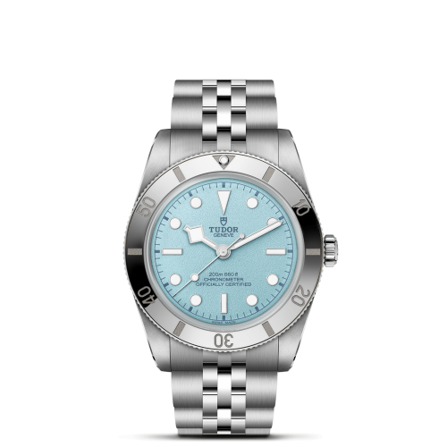 The Tudor M79000-0001 is a silver wristwatch with a light blue dial, white hour markers, and a five-link metal bracelet, displayed on a plain background.