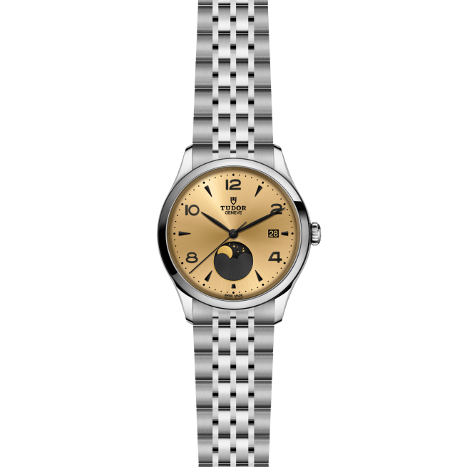 The M91560-0001 is a Tudor wristwatch featuring a gold dial, black Arabic numerals, moonphase display, date window at 3 o'clock, and a silver metal link bracelet.