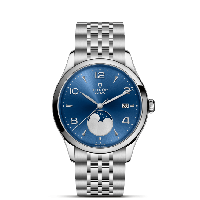 The Tudor M91560-0002 is a stainless steel wristwatch featuring a blue dial, silver hour markers, date at 3 o’clock, moon phase above 6 o’clock, and a metal link bracelet.