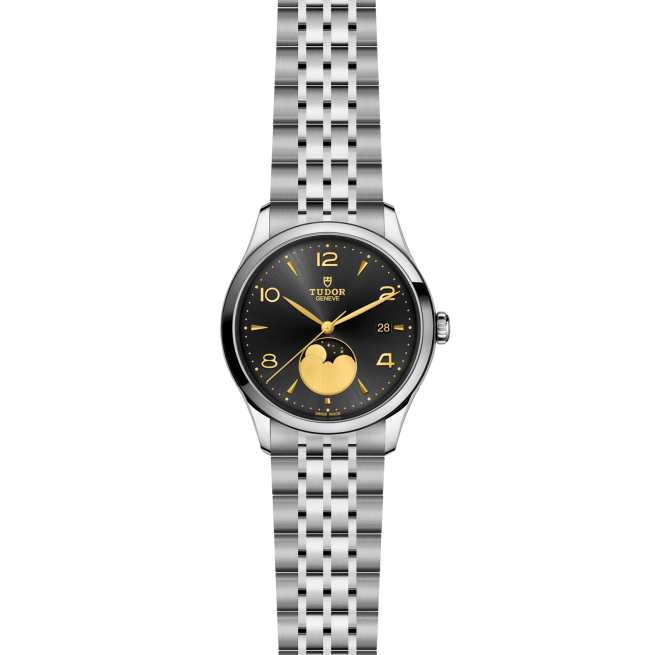 The M91560-0003 is a silver Tudor wristwatch featuring a black dial, gold-tone accents, moon phase subdial, date window, and a stainless steel link bracelet.