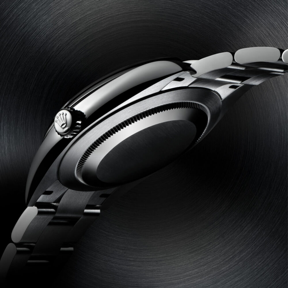 Side view of a modern wristwatch featuring a sleek, stainless steel band and a prominent crown, set against a swirling dark background.