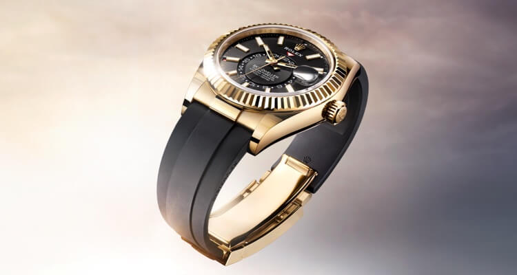 Luxury gold and black wristwatch displayed against a soft gradient background.