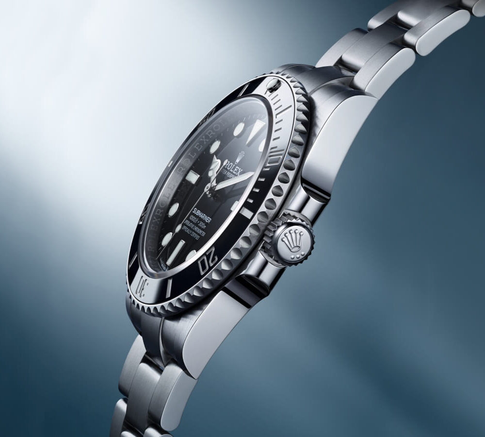 A luxury wristwatch with a stainless steel band and black dial, featuring a date window and brand logo, set against a blurred blue background.