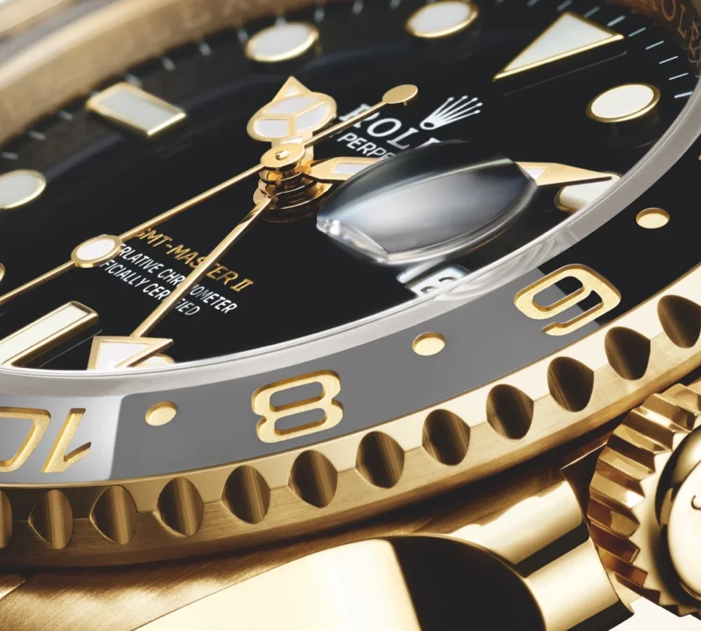 Close-up view of a luxurious gold wristwatch featuring a black dial, luminous hands, and a date display.