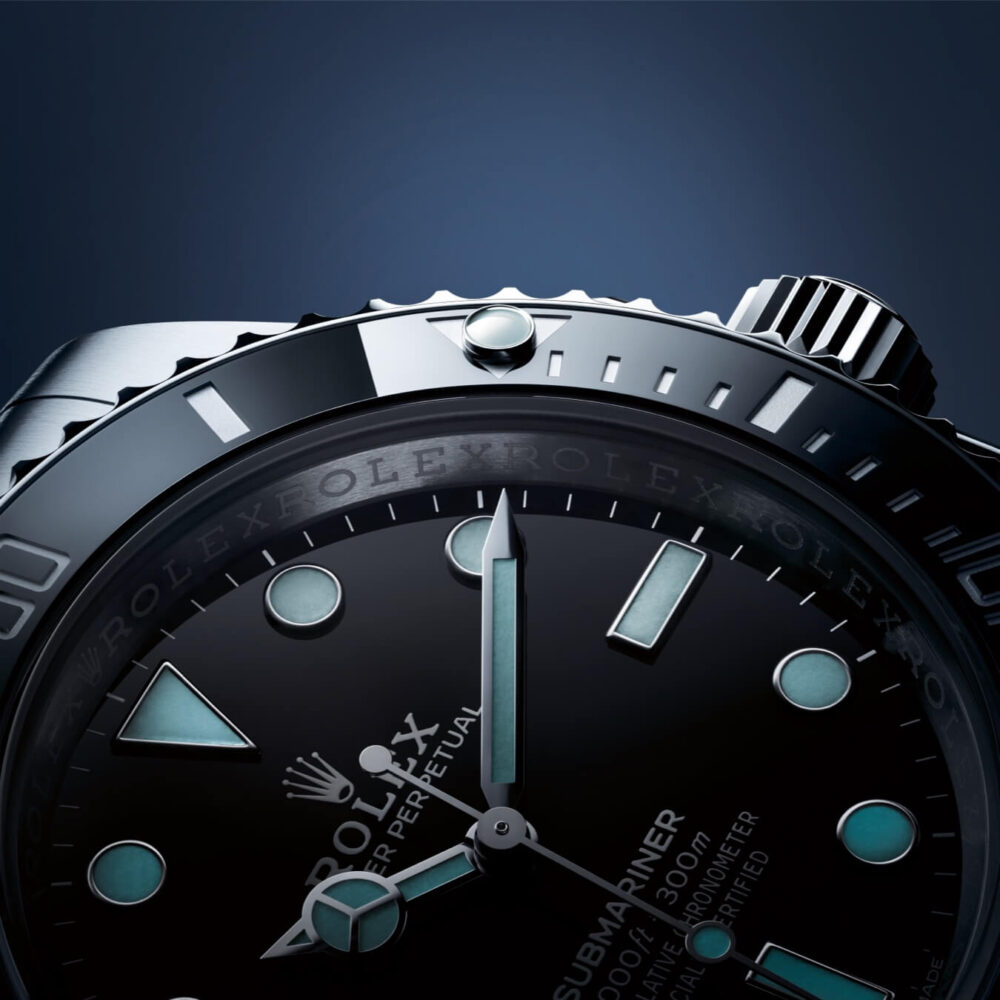 Close-up view of a Rolex Submariner watch, highlighting the brand logo and watch hands on a dark watch face against a blue background.