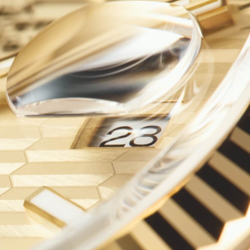 Close-up view of a gold watch showing the date under a magnifying glass.