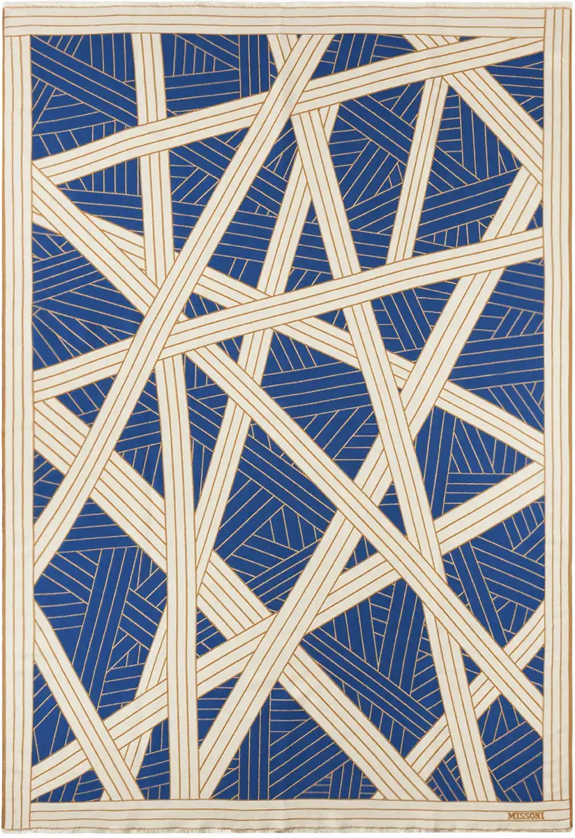 Abstract geometric pattern with interlacing blue and white lines on a textile, signed by Missoni in the bottom right corner.