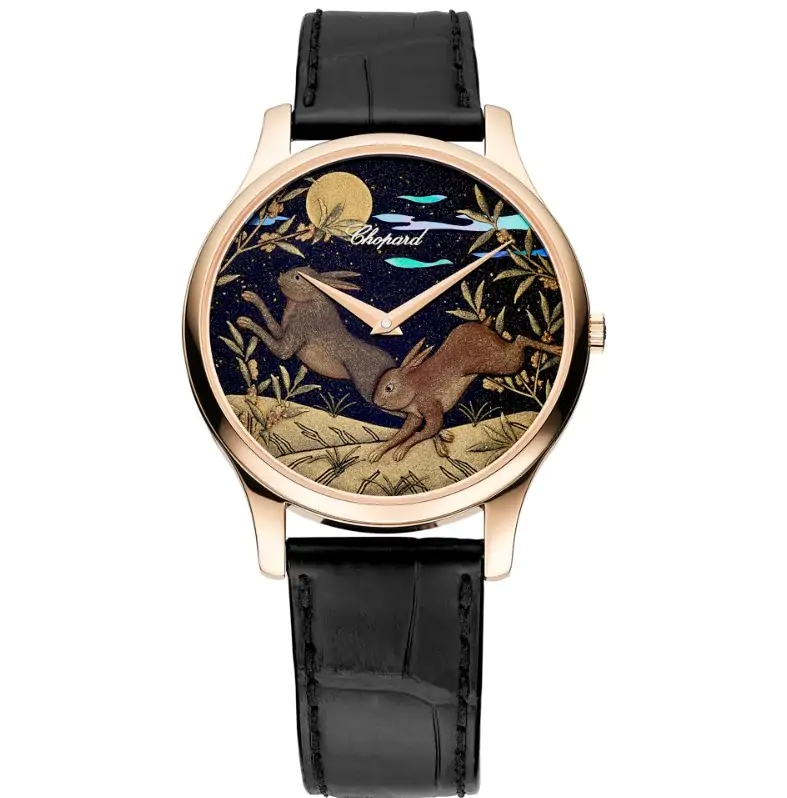 A Chopard watch with a black leather strap, featuring a dial depicting two rabbits under a starry night sky in a gold and black color scheme.