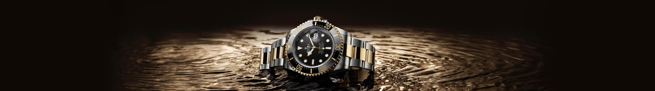 Luxury watch on a reflective water surface with ripples, highlighted by a spotlight against a dark background.